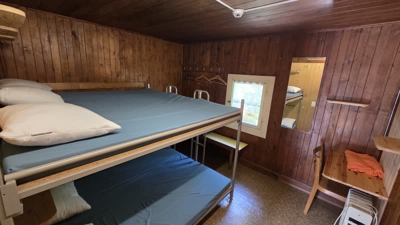 Zimmer 3 mit Etagenbett, Spiegel, Tischchen und getäferten Wänden